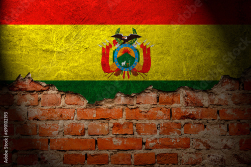 A wall with a painting of the Bolivia flag at night.