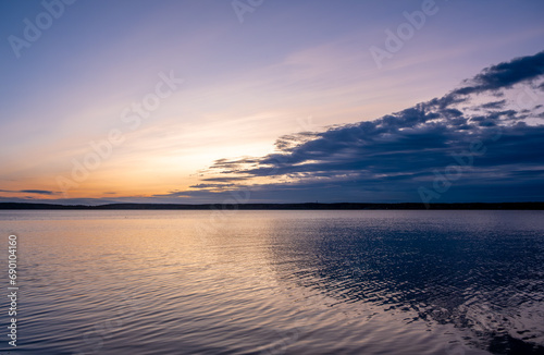 Sunrise over the lake in the early summer morning.