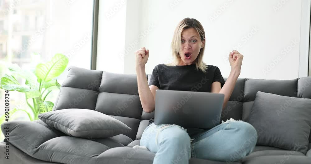 Woman sitting on sofa and rejoicing at good news on laptop 4k movie slow motion. Successful online business concept Woman sitting on sofa and rejoicing at good news on laptop 4k movie slow motion. Successful online business concept