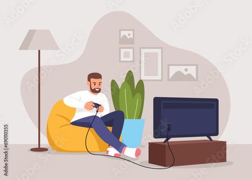 Man playing video games while sitting on an ottoman at home
