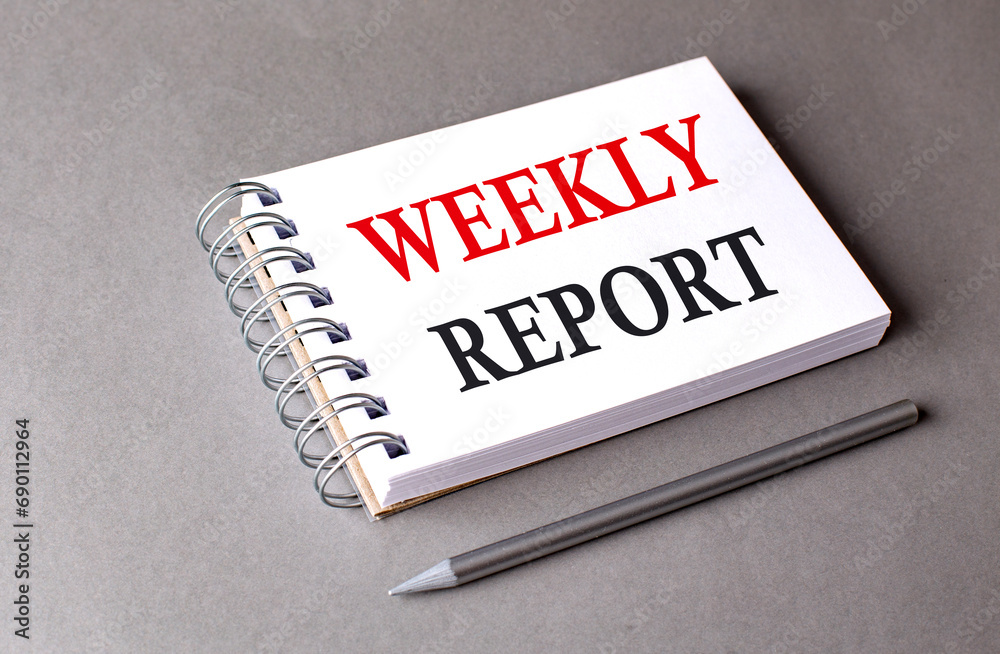 WEEKLY REPORT word on notebook on grey background