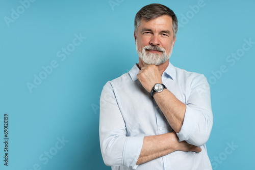 Portrait of happy casual older man smiling, Mid adult, mature age male with gray hair, Isolated on blue background photo
