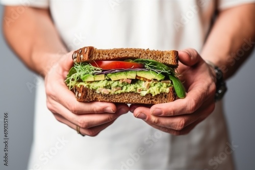 avocado sandwich in human hands