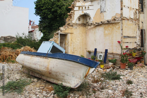 Ruined house and a fishing boat in the traditional Greek village of Kokkaroi on the island of Samos