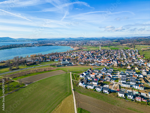 Luftbild von der Gemeinde Markelfingen und dem Neubaugebiet mit dem Bodensee und Radolfzell sowie Singen und der Burg Hohentwiel im Hintergrund
