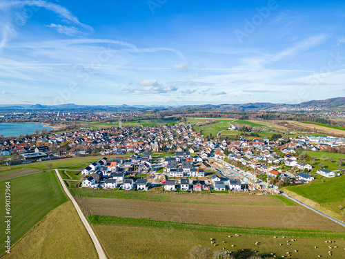 Luftbild von der Gemeinde Markelfingen und dem Neubaugebiet mit dem Bodensee und Radolfzell sowie Singen und der Burg Hohentwiel im Hintergrund