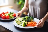 woman arranging steamed veggies on a plate