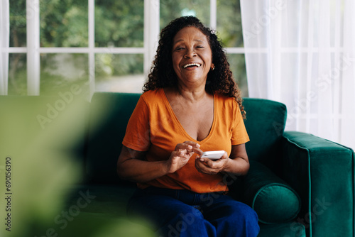 Happy black woman enjoying using mobile apps for seniors on her smartphone