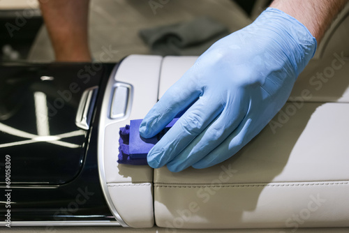 The process of applying a protective ceramic composition to the leather interior of the car interior. The concept of protecting and restoring the leather interior of the car. Automotive ceramics.  photo
