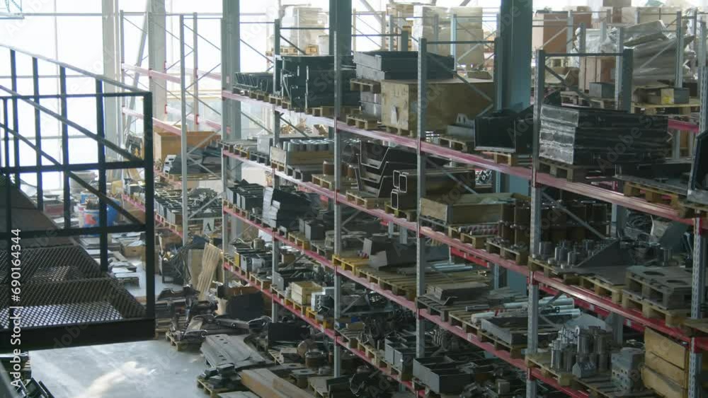 Wide no people high angle shot of warehouse with goods and spare parts on multiple storage shelves at manufacturing factory