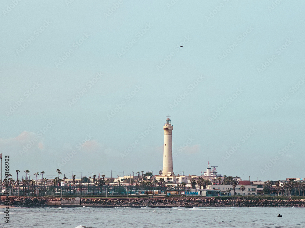 view of The El Hank lighthouse  seen from Hassan II Mosque Park , it is a lighthouse located on the tip of El Hank, west of the port of Casablanca, Morocco