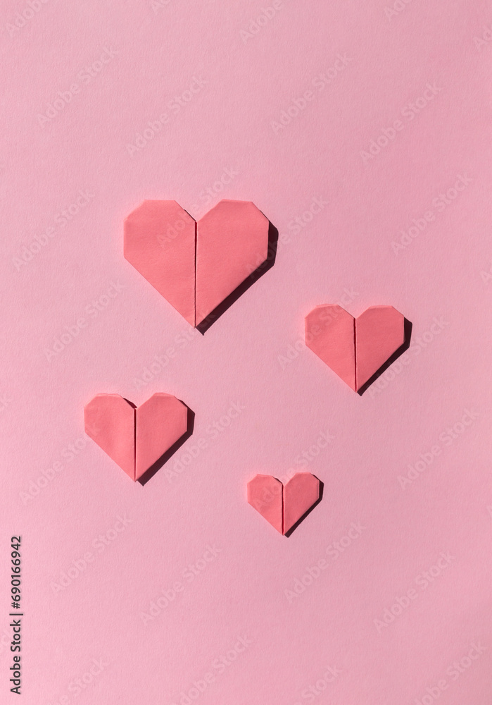 Pink paper origami hearts on the pink background. Valentine's day celebration concept