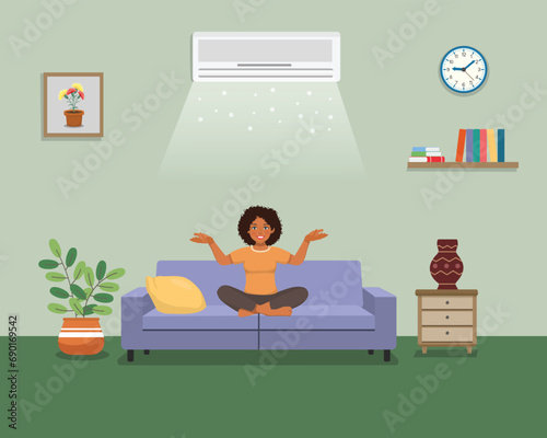 Young African woman sitting on sofa relaxing enjoying under air cooling with Air Conditioner at home