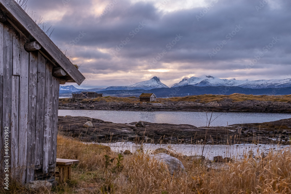 fisherman wooden cabins on coast of norwegian sea with mountains on background
