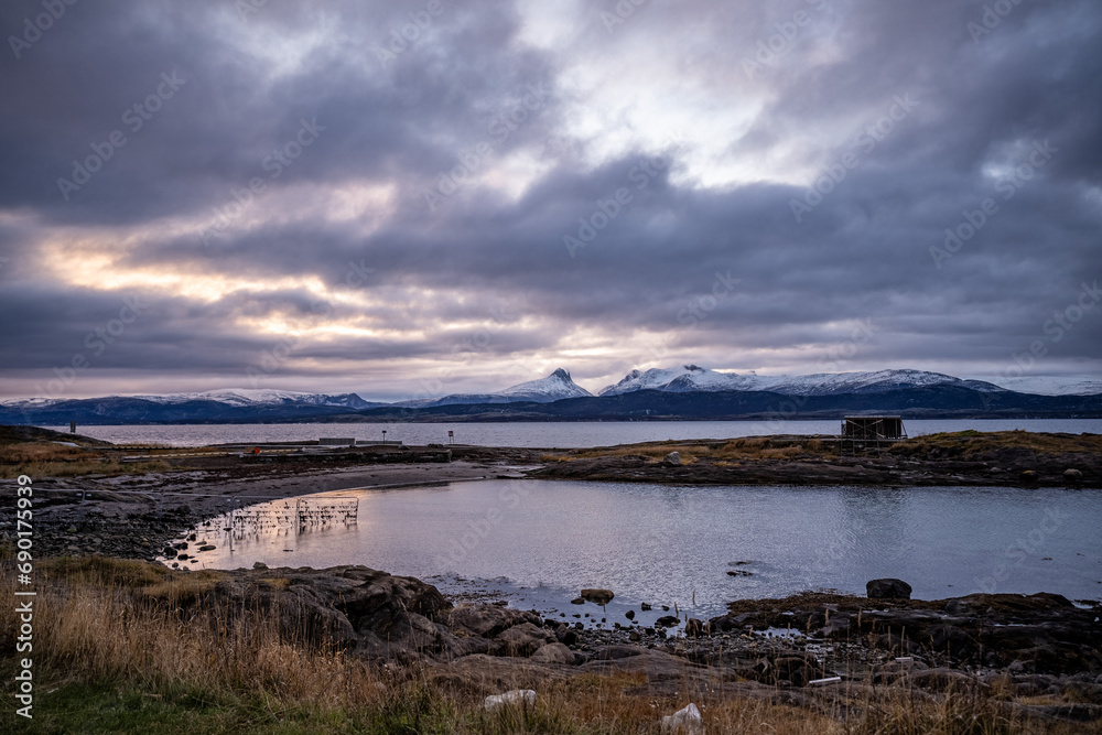 coastline of norwegian sea in bodo with snowy mountains on background