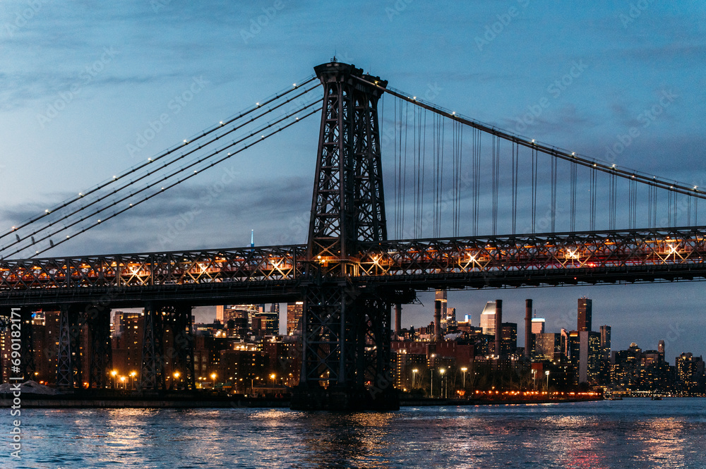 Fototapeta premium Illuminated bridge over river in evening city