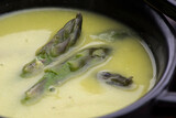 Green spring pureed asparagus soup served in plates