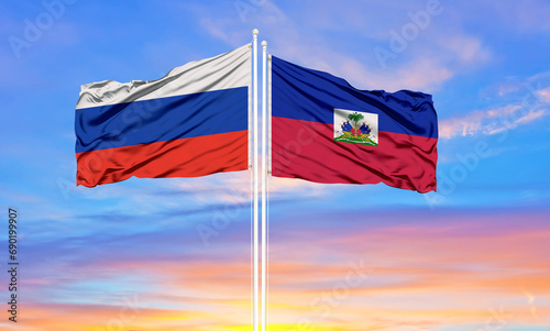 Φωτογραφία Russia and Haiti two flags on flagpoles and blue sky.