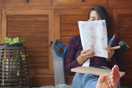 Gros plans de pieds en détail, d'une femme détendue et lisant une notice de montage