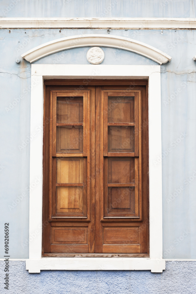 Wooden door. Peeling paint wood. Home exterior facade. Single wood frame isolated on wall. Closed window shutter. Balcony door isolated. Wooden door. Peeling paint wood. Home exterior facade. Single wood frame isolated on wall. Closed window shutter. Balcony door isolated.
