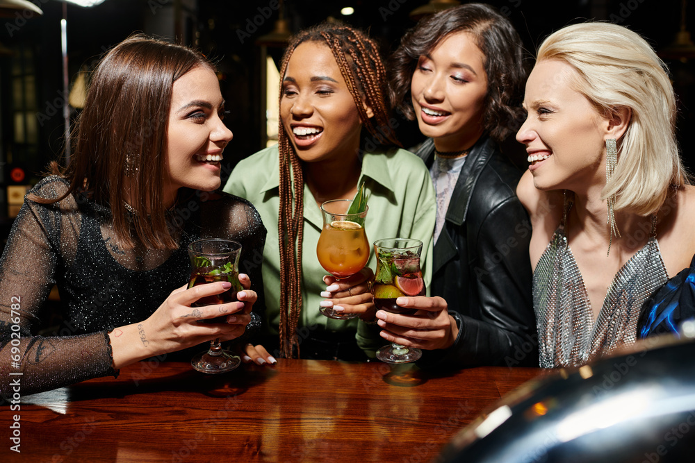 cheerful multiethnic girlfriends with delicious cocktails talking during party in bar, leisure cheerful multiethnic girlfriends with delicious cocktails talking during party in bar, leisure