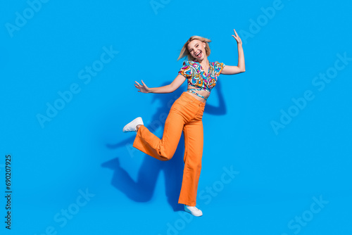 Full body photo of lovely crazy lady have good mood dancing chilling isolated on blue color background