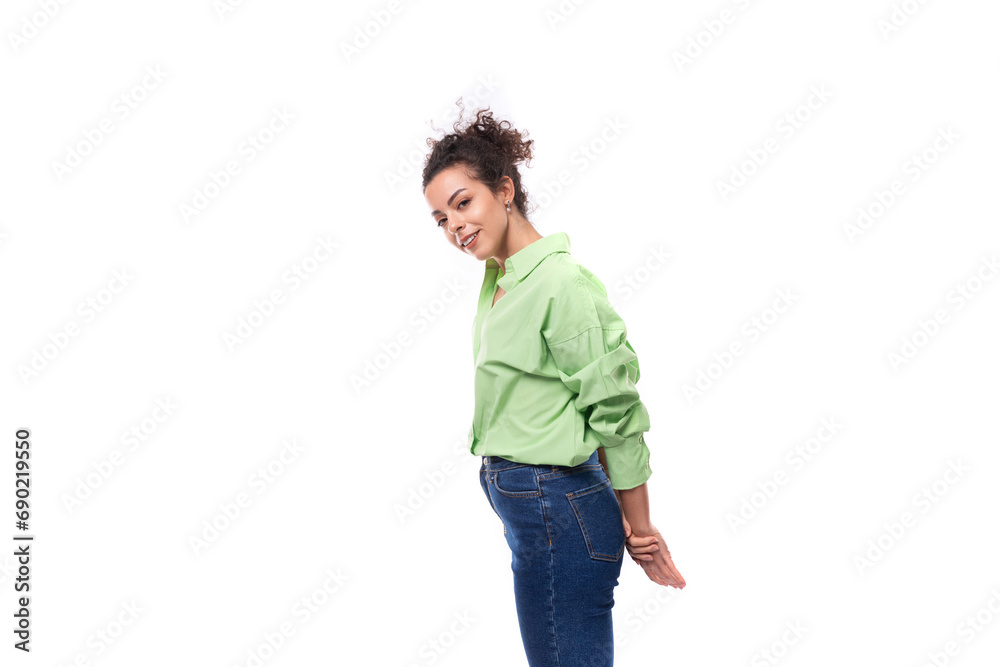 young well-groomed slender European brunette curly woman dressed in a green shirt on a white background young well-groomed slender European brunette curly woman dressed in a green shirt on a white background