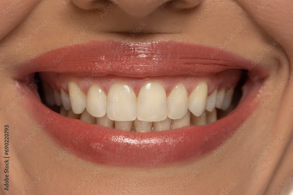 Fototapeta premium Close-up of a woman's mouth, capturing a confident smile and perfect natural teeth and lips