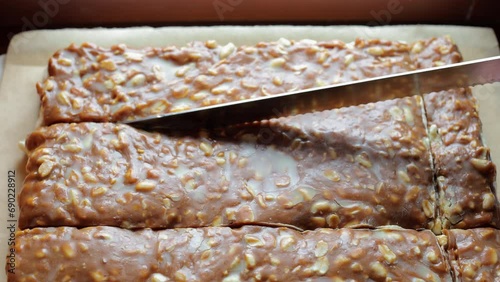 Cutting caramel peanut cake. Woman's hand cuts cake