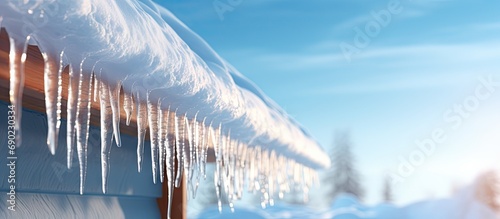 Ice dam in gutter and ice frozen on roof in winter focus on icicles in foreground. Website header. Creative Banner. Copyspace image