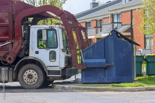 Municipal sanitation disposal service recycling garbage collector truck loading waste trash bin photo
