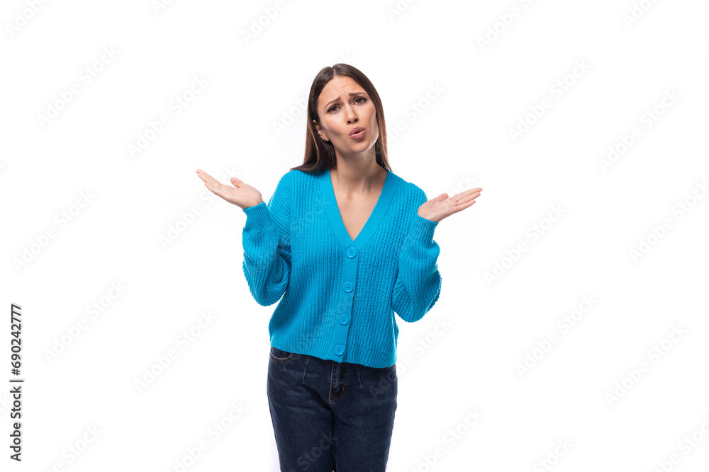 young pretty brunette woman dressed in a blue cardigan on a white background with copy space young pretty brunette woman dressed in a blue cardigan on a white background with copy space