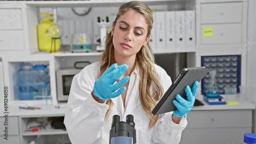 Wallpaper Mural Attractive young blonde scientist analyzing blood through test tube using touchpad at a busy lab, poised amidst modern medical technology Torontodigital.ca