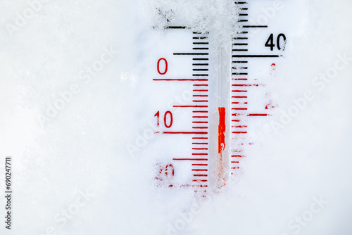 Outdoor thermometer in snow shows cold winter temperature photo
