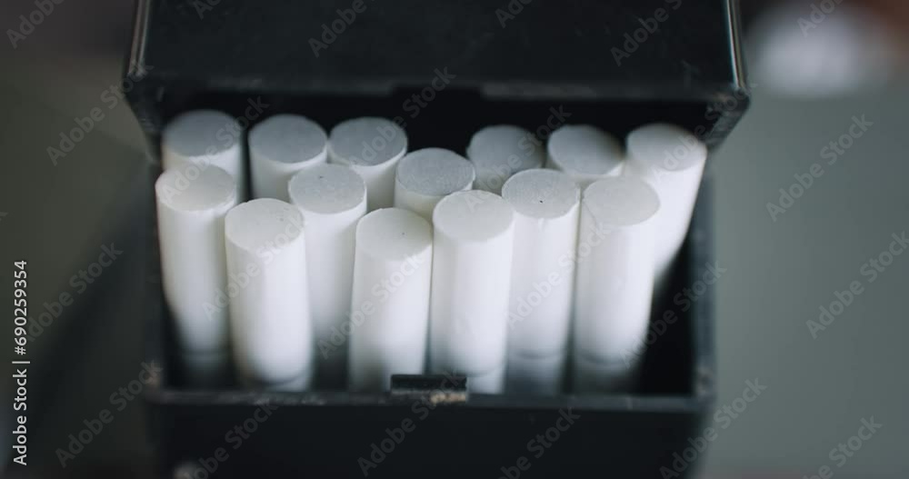 Oppening a black box package of unbranded tobacco cigarettes, slow motion, cinematic isolated shot Oppening a black box package of unbranded tobacco cigarettes, slow motion, cinematic isolated shot
