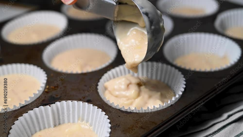 Filling the cupcake paper holders with the raw dough, cooking muffins. Filling the cupcake paper holders with the raw dough, cooking muffins.