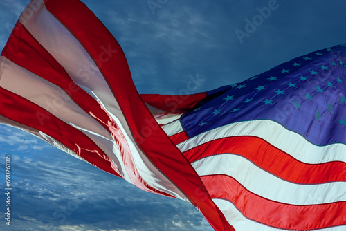 Breeze blows American flag of the United States against blue sky