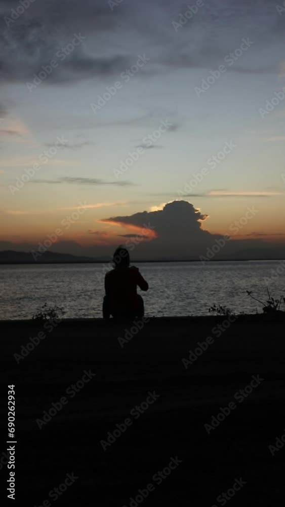 Vertical video of silhouette of a man on the lake at sunset Vertical video of silhouette of a man on the lake at sunset