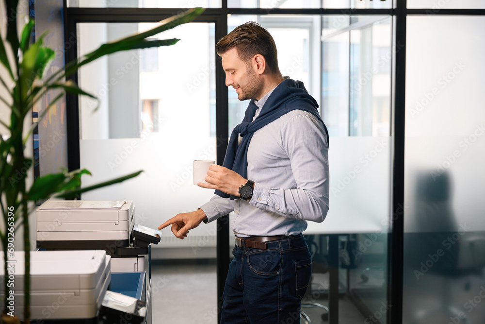 Fototapeta premium Man prints out work documents on office equipment