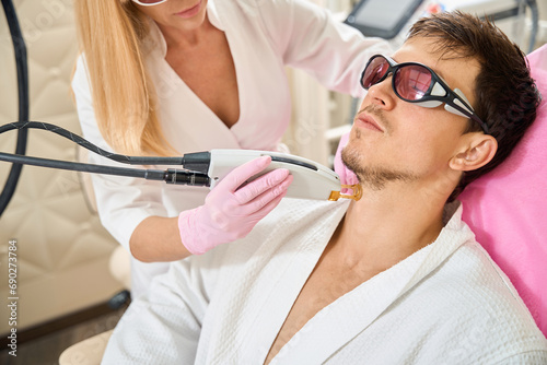 Man  client of beauty salon undergoing laser hair removal procedure