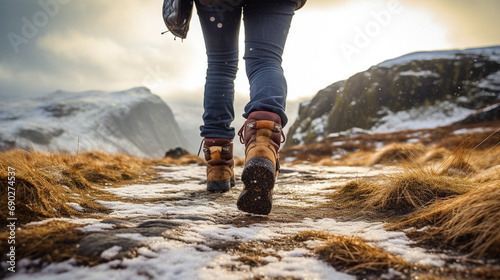 Trekking or hiking on a winter trail. Close up shot of hiking boots or shoes. Outdoor path with snow and water. Detail photo of outdoor hiking boots. © © Raymond Orton