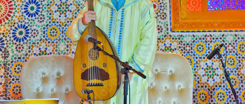 A Moroccan musician wearing a Moroccan djellaba plays the Oud photo