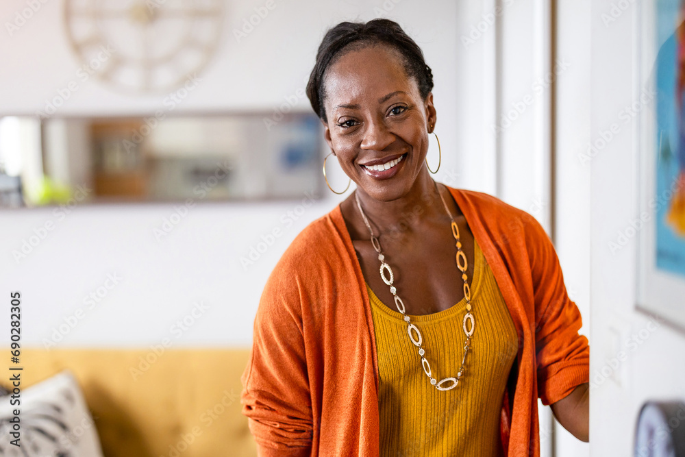 Fototapeta premium Portrait of a smiling mature woman standing in her apartment 