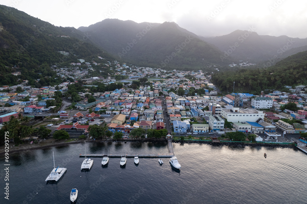 Fototapeta premium Aerial top down view of the city of Soufriere with Pitons in the background. Shot on a DJI Drone Air 2s in the Caribbean on beautiful Saint Lucia island. Colorful houses throughout the town.