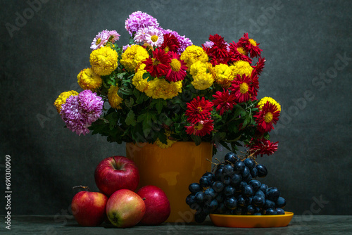 Foto Still life with a bouquet of chrysanthemums and fruits