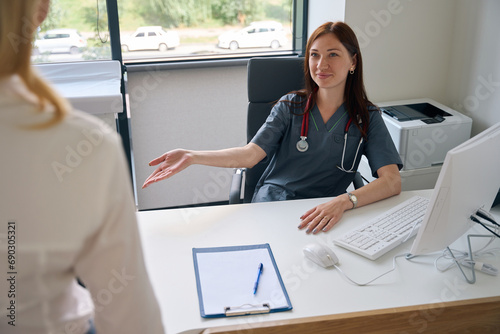 Friendly doctor receiving person in her office