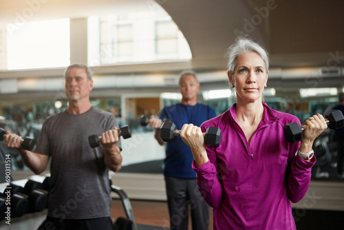 Senior fitness club, people and dumbbells at gym for training, health and wellness, sport or exercise. Class, workout and elderly group of friends at a studio for hand weight, cardio or weightlifting