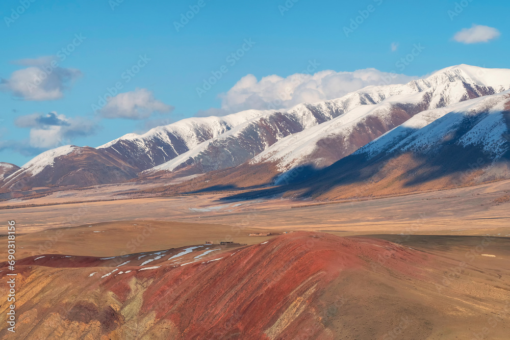 Unusual texture of the mountains, there is snow in the veins of the rock, the surface of the plateau is heated by the sun. Amazing red mountain plateau at sunset is lightly sprinkled with snow.