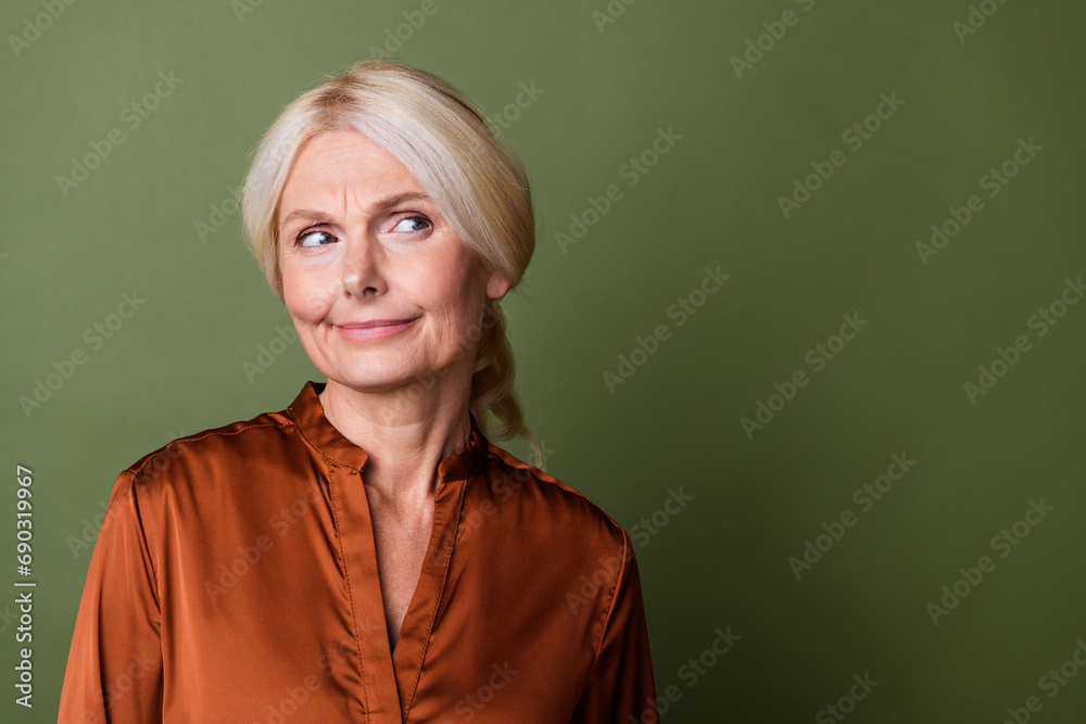 Obraz premium Photo portrait of pretty retired female look skeptical empty space dressed stylish brown silk outfit isolated on khaki color background