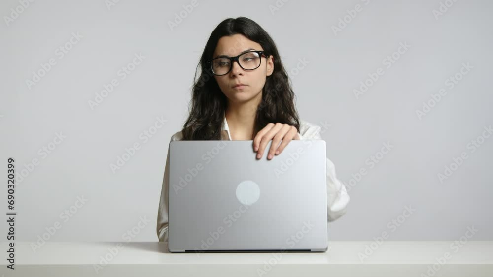 A businesswoman in a white office finishes her work on the laptop. She closes it, stands up, and exits the frame. High quality 4k footage A businesswoman in a white office finishes her work on the laptop. She closes it, stands up, and exits the frame. High quality 4k footage